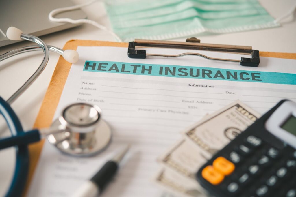 stethoscope and calculator placed on health insurance documents, begging the question, "does Medicaid cover rehab?