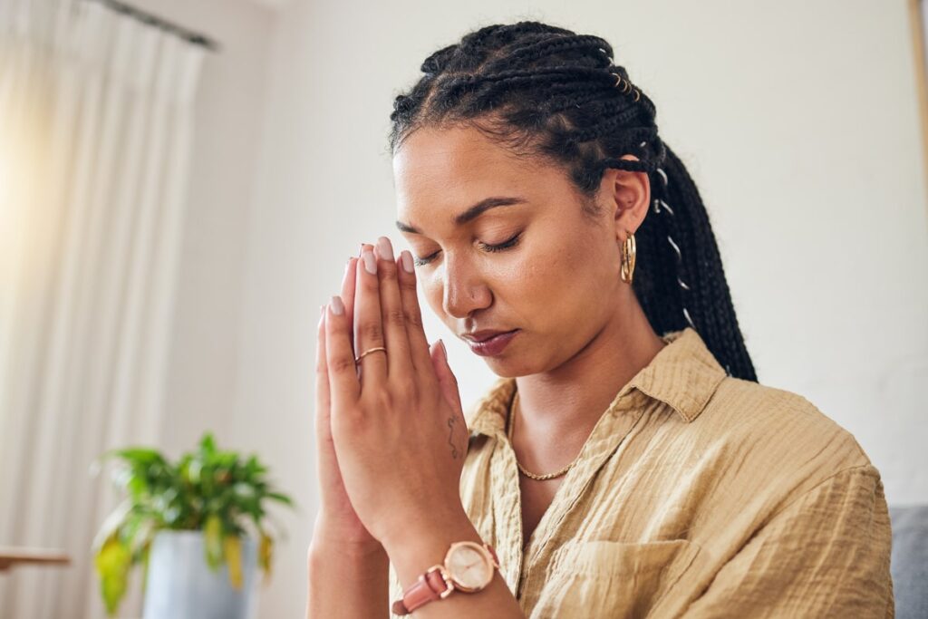 An image of a person sitting alone in a church pew, illustrating the role of religion in addiction recovery.