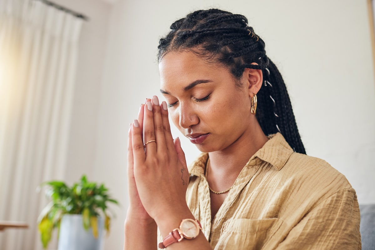 An image of a person sitting alone in a church pew, illustrating the role of religion in addiction recovery.