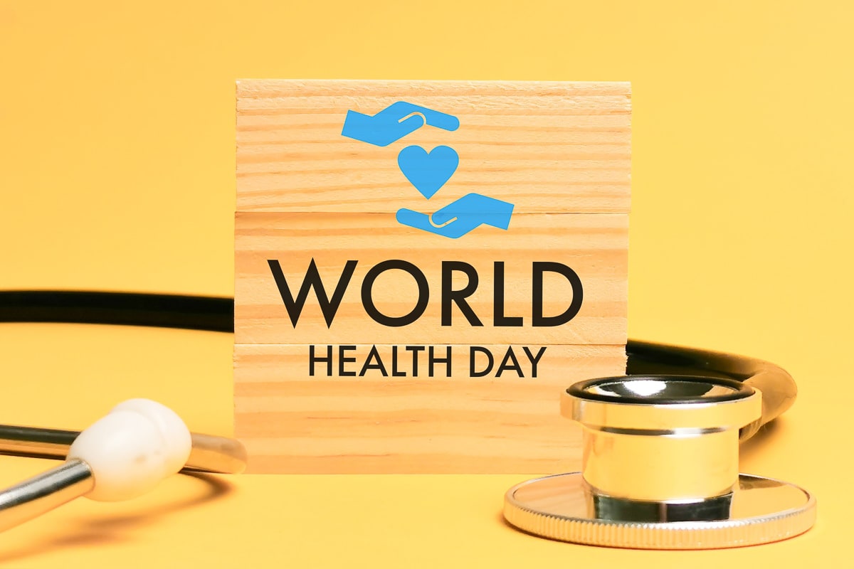 A wooden sign with the words 'World Health Day' written upon it, set against a background of a stethoscope